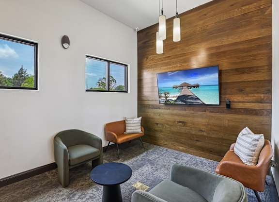 A living room with a flat screen TV mounted on a wooden wall.
