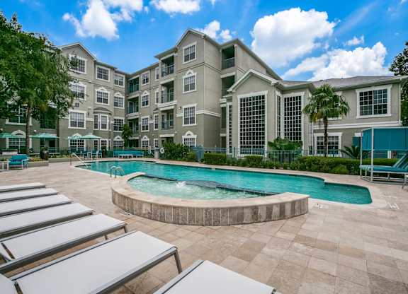 Townhomes for Rent in Houston, TX - The Maroneal - Resort Style Pool with Hot Tub, Lounge Seating, Palm Trees, and Greenery