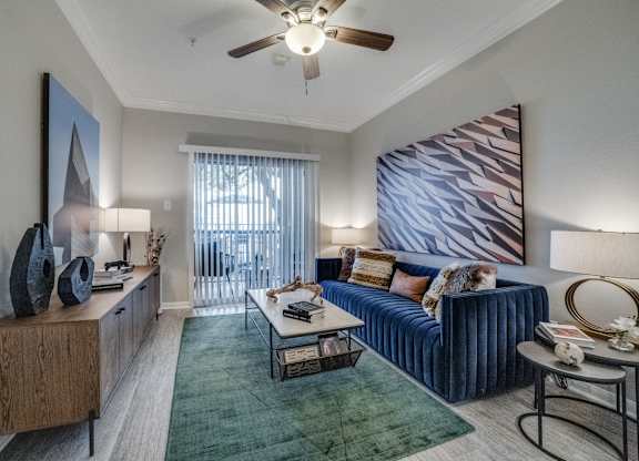 a living room with a blue couch and a ceiling fan