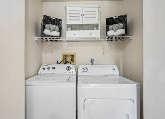A white washing machine and dryer in a small laundry room.