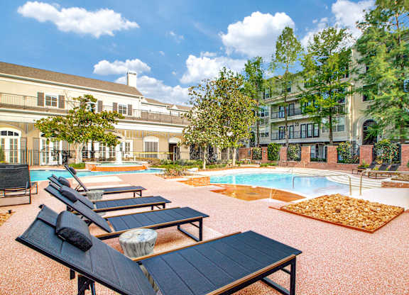 A pool area with sun loungers and a table.