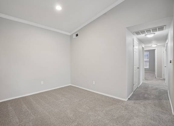 A spacious room with carpeted floor and white walls.