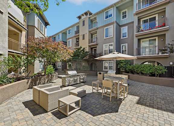 A patio with a table and chairs surrounded by buildings.