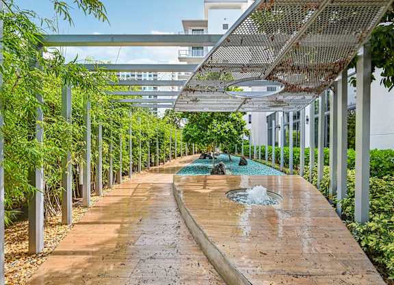 A walkway with a fountain in the middle of it.