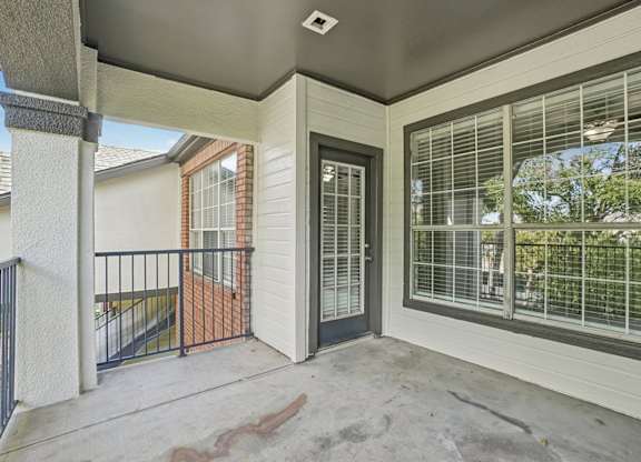 A patio with a black gate and a black railing.