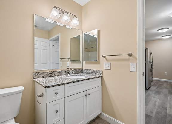 A bathroom with a white tub and sink vanity.