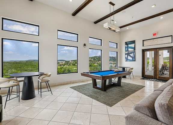 A room with a pool table and a view of the outside.