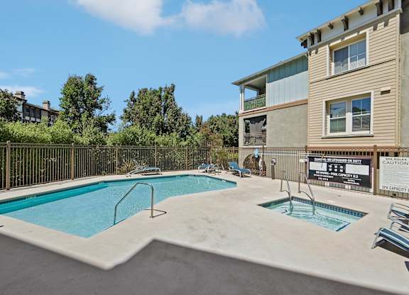 A swimming pool in a residential area with a caution sign.