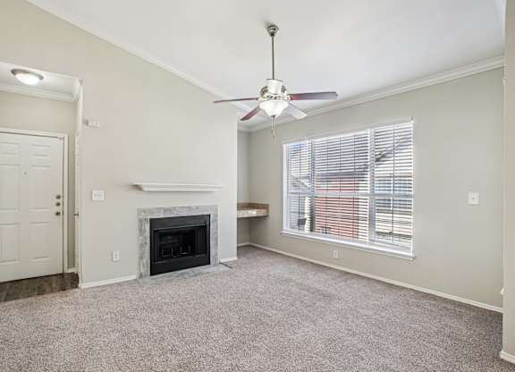 A room with a fireplace and a ceiling fan.