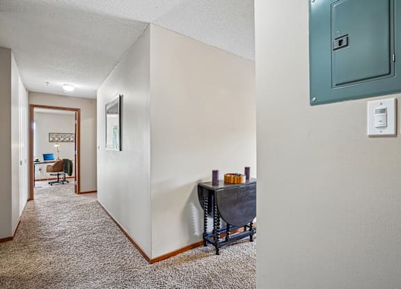 A hallway with a table and chairs in the middle.