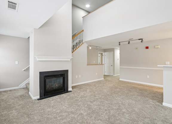 A living room with a fireplace and a staircase.