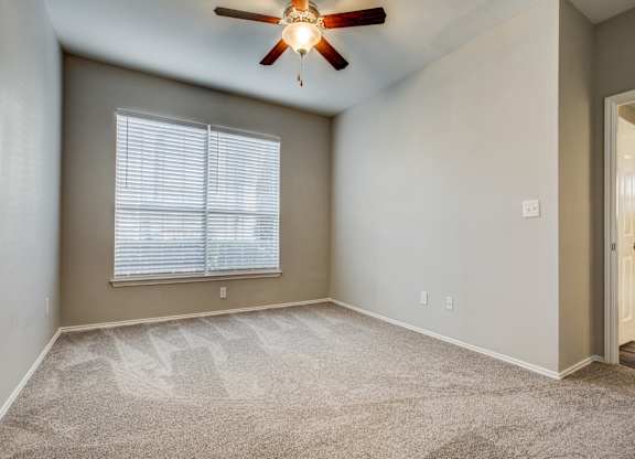 Apartments for Rent in Plano TX - Carrington Park - Bedroom with Carpeting, Beige Walls, and Large Window
