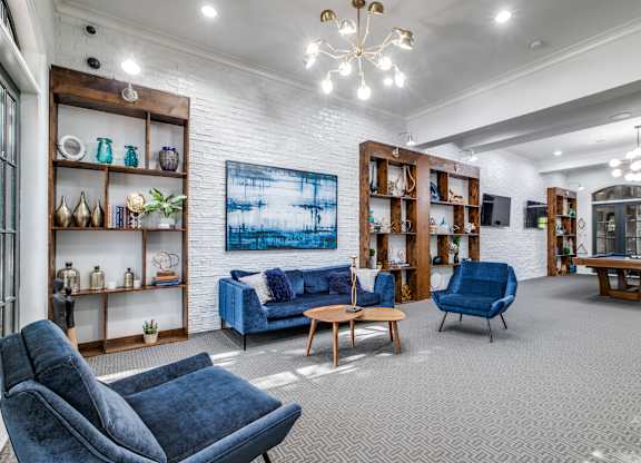 A living room with a blue sofa and grey carpet.