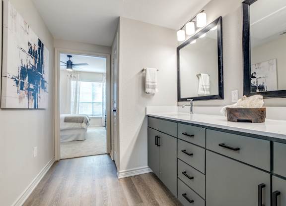 A bathroom with a large mirror and a painting on the wall.