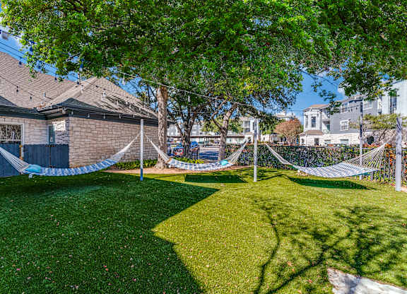a yard with hammocks in the yard of a house