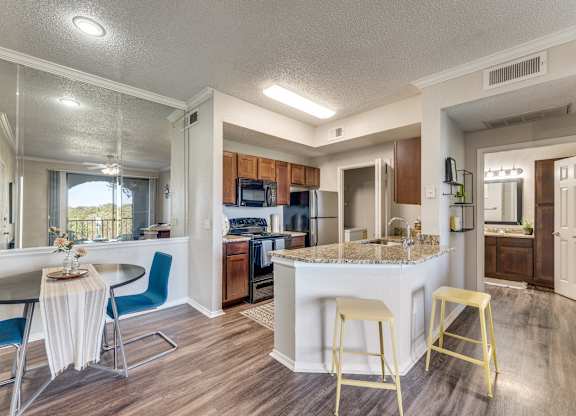 a kitchen with a breakfast bar and a table with chairs