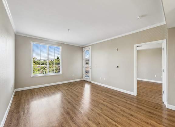 A large empty room with wooden floors and white walls.
