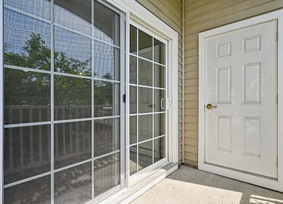 A white door is on the right of a sliding glass door.