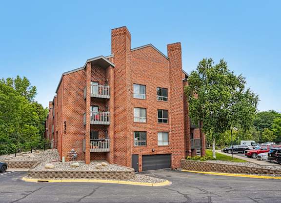 A red brick building with a parking lot in front.