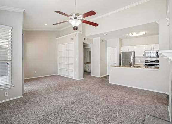 A room with a ceiling fan and carpeted floor.