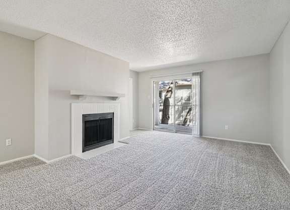 A room with a fireplace and a carpeted floor.