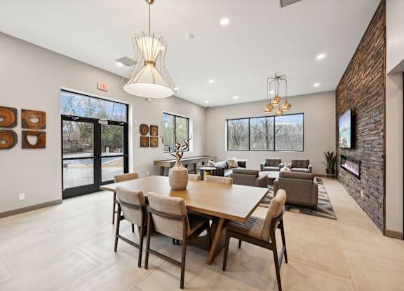 a dining room with a large table and chairs and a living room with couches