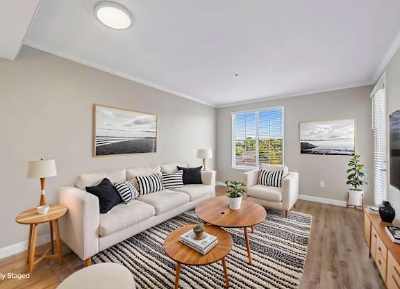 A living room with a white sofa and a wooden coffee table.