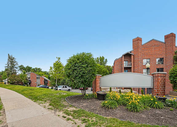 A red brick building with a sign in front of it.