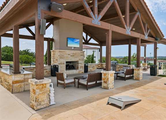 A patio with a fireplace and seating area.