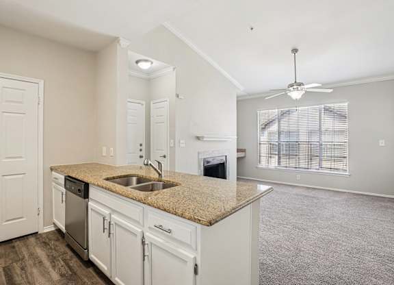 A kitchen with white cabinets and a granite countertop.