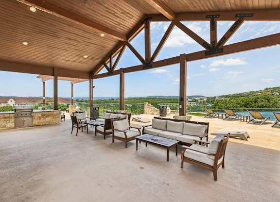 A patio with a table and chairs overlooking a scenic view.