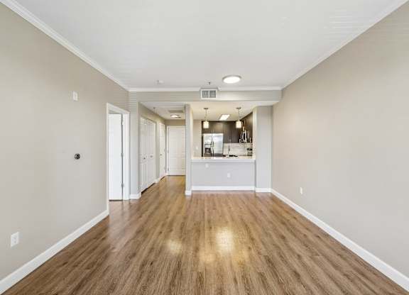 A long, empty hallway with wood floors and white walls.