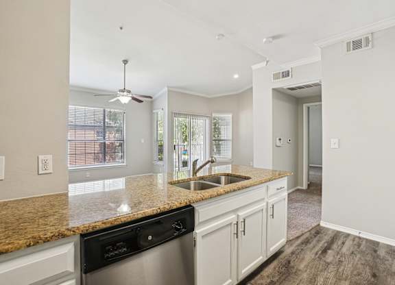 A kitchen with a granite countertop and stainless steel appliances.