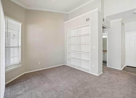 A room with a white door and a window with blinds.