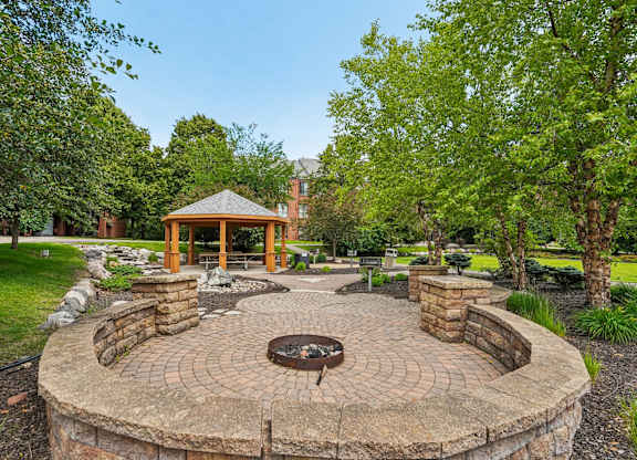 A gazebo is surrounded by a circular brick patio.