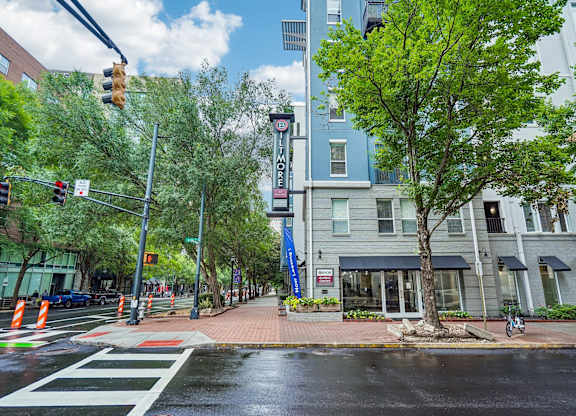 A street view with a crosswalk, traffic lights, and a building with a sign that reads