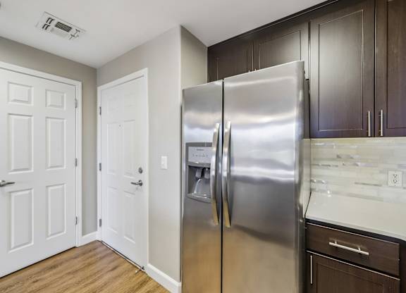 A kitchen with a stainless steel refrigerator and white doors.