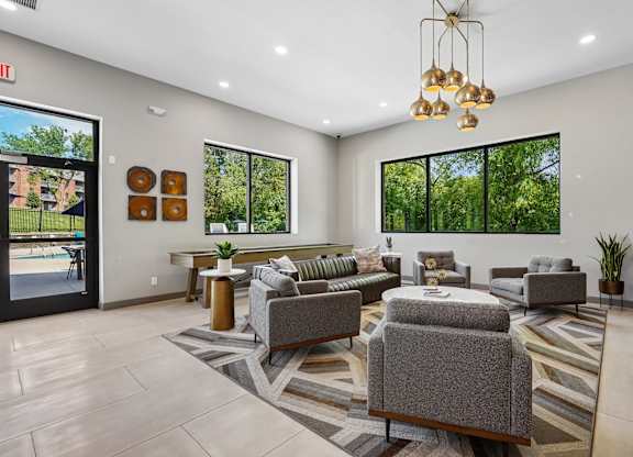 A spacious waiting room with grey couches and a striped rug.
