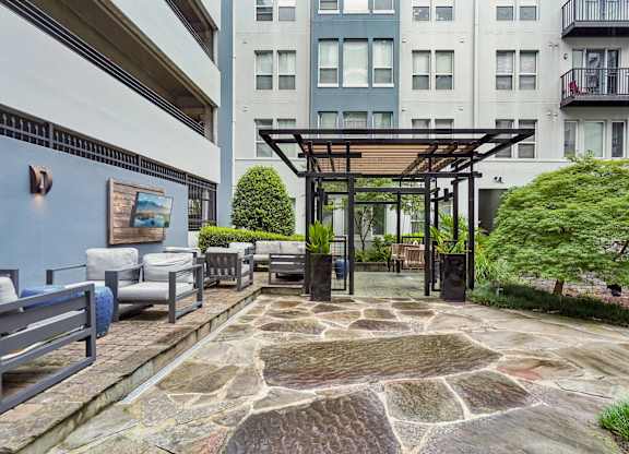 A patio with a stone floor and a pergola.