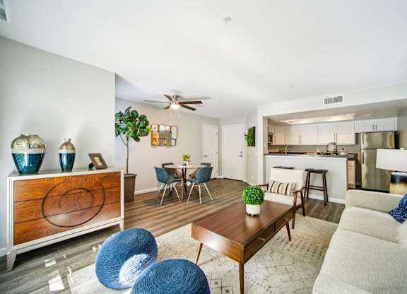 A modern living room with a dining area and kitchen in the background.