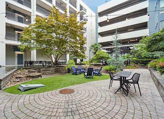 A courtyard with a table and chairs surrounded by buildings.