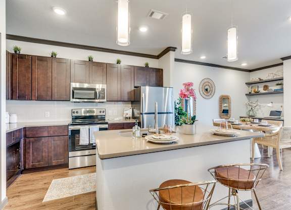 a kitchen with a bar and a dining area with chairs