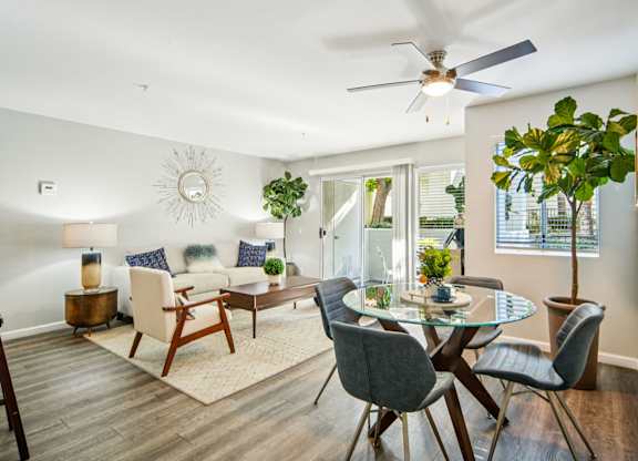A modern dining room with a glass table and chairs.