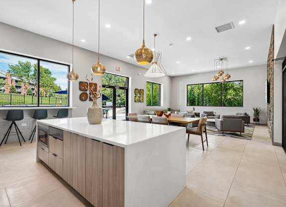 A modern kitchen with a large island and pendant lights.