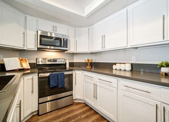 A kitchen with white cabinets and a stainless steel oven.