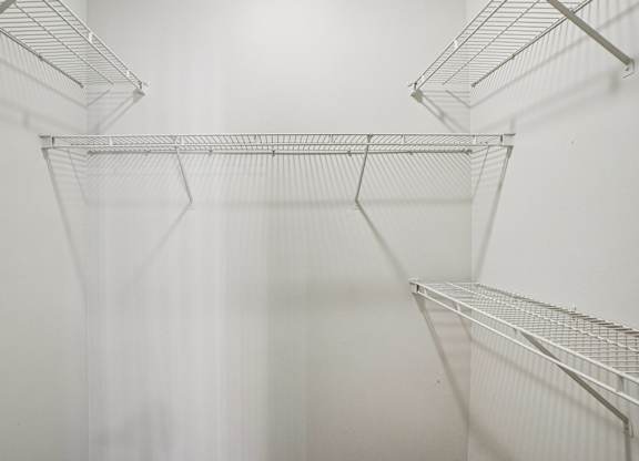 Empty wire shelves in a white room.