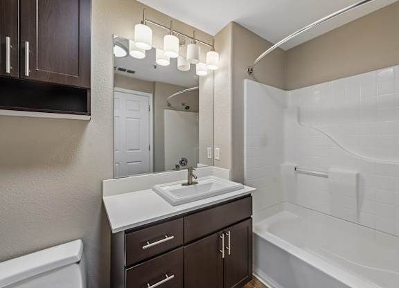 A bathroom with a white sink and a white bathtub.