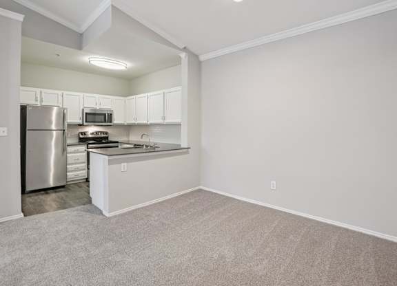A kitchen with a refrigerator, microwave, and oven.
