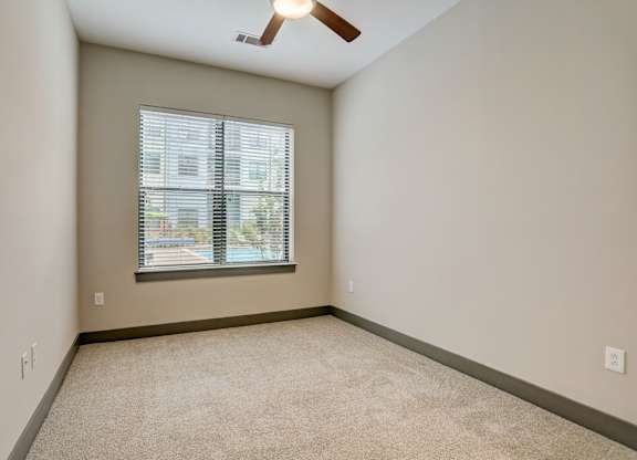 Pet-Friendly Apartments in Nashville, TN- Octave Apartments-  Bedroom with plush carpet and a ceiling fan