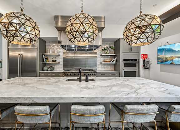 A modern kitchen with a marble table and chairs.
